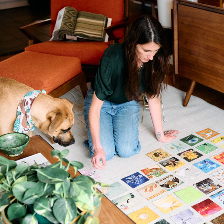 Woman and dog looking at archetype cards for a Source Session with Modern Magic 
